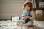 Kind umarmt Bloki Handpuppe und sucht Sicherheit und Geborgenheit im Kinderzimmer